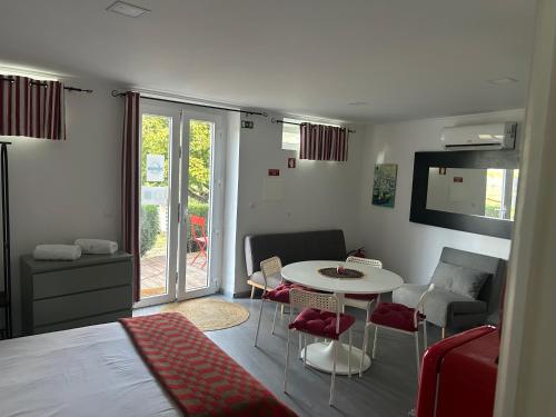 een kamer met een bed, een tafel en stoelen bij Casa Do Refugio Guest House in Covilhã