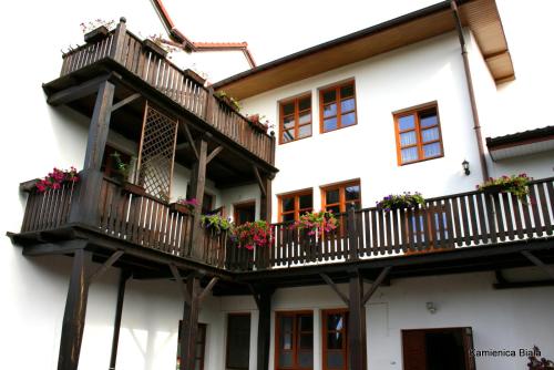 a building with a balcony with flowers on it at Kamienica Biała in Kazimierz Dolny