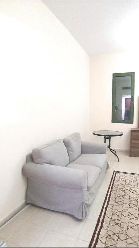 a white couch in a living room with a table at Dragon Golden Apartment 2 in Dubai