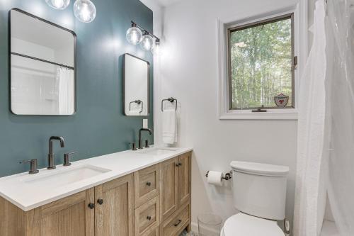 a bathroom with a toilet and a sink and mirrors at 6 Mi to Bushkill Falls Secluded Home with Game Room in Saw Creek