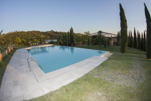 uma grande piscina num quintal com árvores em Agriturismo Sant'Alfredo em Monteroni dʼArbia