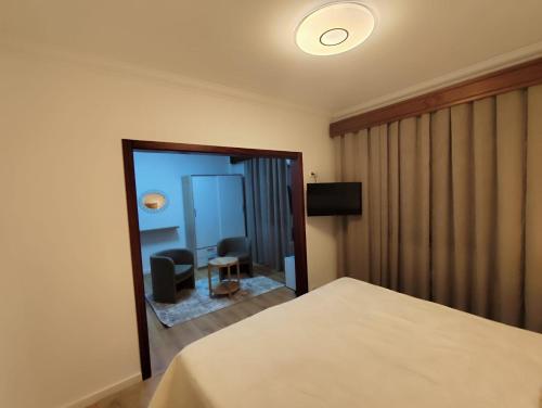 ein Hotelzimmer mit einem Bett und einem Spiegel in der Unterkunft Residencial Pôr do Sol in Couço