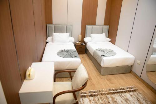 a small room with two beds and a chair at lotus view El tahrir in Cairo