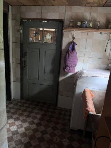 a small bathroom with a door and a towel at Chalé do lago rústico in Campo Alegre
