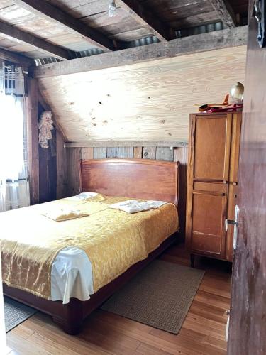 a bedroom with a bed with a wooden head board at Chalé do lago rústico in Campo Alegre