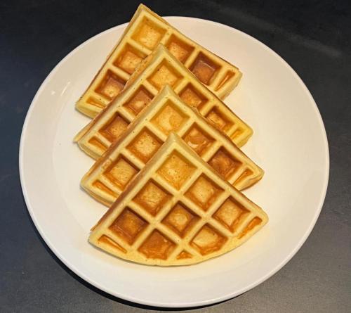 three waffles on a white plate on a table at Baliem CoLiving in Jimbaran