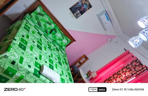 a bedroom with a green christmas tree on the wall at manoir hoome in Bonabéri