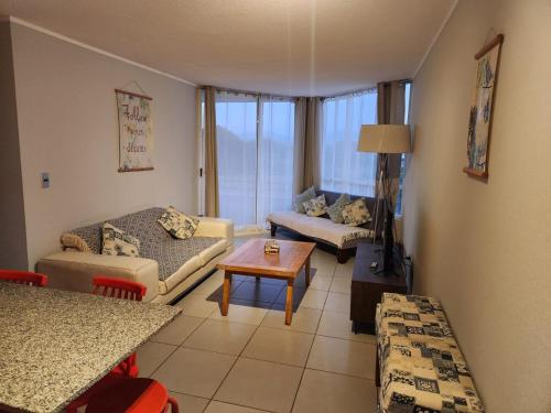 una sala de estar con un sofá y una mesa en Descanso frente al mar, en Los Molles