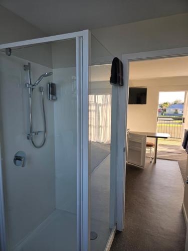 a bathroom with a shower with a glass door at Monarch Motel in Invercargill