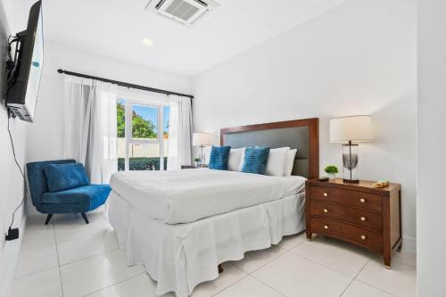 a bedroom with a large bed and a blue chair at Arubas Life 108 in Noord