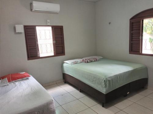 アウテル・ド・ションにあるAlter do Chão- Casa 01のベッドが2つと窓が2つある寝室