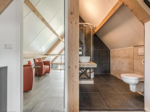 ein Bad im Dachgeschoss mit einem WC und einem Tisch in der Unterkunft Luxury farmhouse in Baarle-nassau in Schaluinen