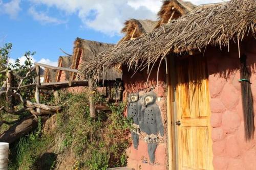 un bâtiment avec une horloge sur le côté dans l'établissement Cabañas lago piuray, à Chincheros