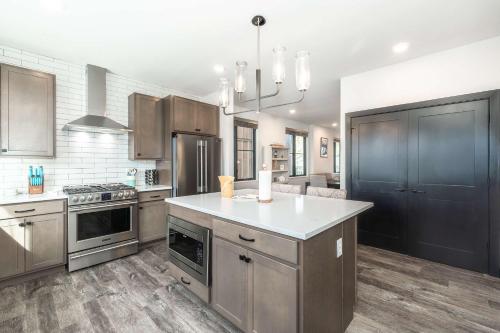 una cucina con armadi in legno e piano di lavoro bianco di Solstice Abode a Hideaway Park