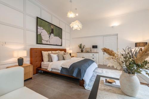 a bedroom with a bed and a vase of flowers at Gorgeous Grand 1000m2 Villa - 5BR with pool in D2 by Ray 02 in Ho Chi Minh City