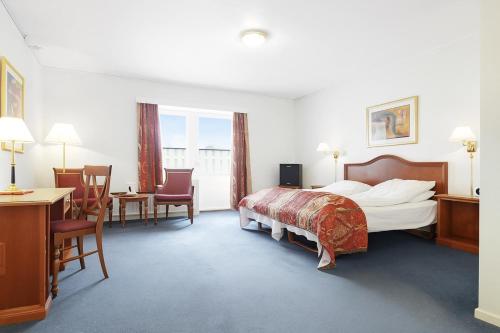 a hotel room with a bed and a table and chairs at Hotell Heia-Elverum-Flisa-Våler i Solør in Våler i Solør