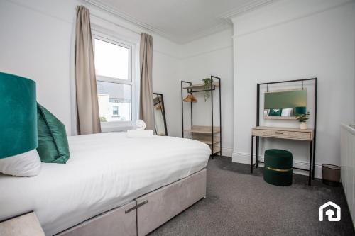 une chambre avec un grand lit et un miroir dans l'établissement Jackson Street Wi-fi Parking Vacant Nest, à Tynemouth