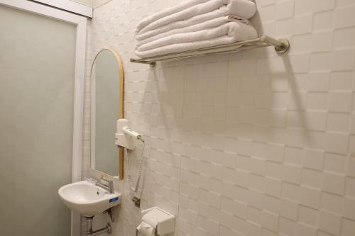 金巴兰Baliem Resort Jimbaran的带水槽、镜子和毛巾的浴室