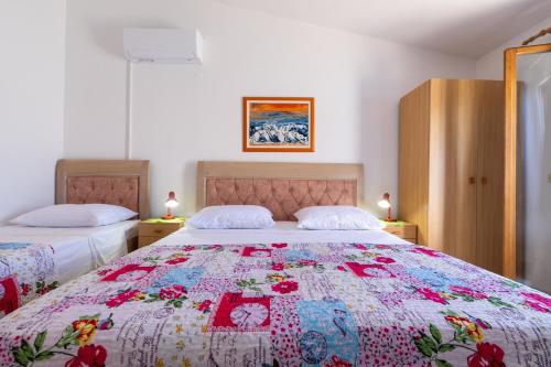 a bedroom with two beds with a colorful quilt at Apartment Solotisa 4623a in Bogomolje