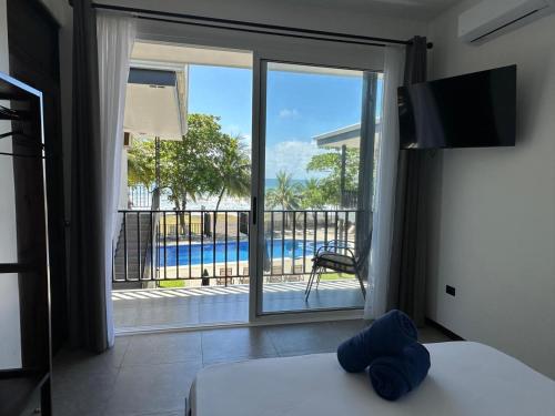 een slaapkamer met een glazen schuifdeur naar een zwembad bij BigWave Costa Rica in Playa Hermosa