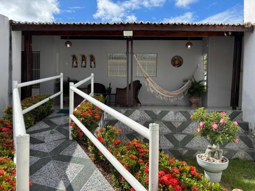 a porch of a house with flowers and a hammock at Aconchego do sertão in Piranhas