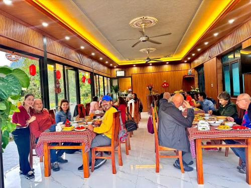 a group of people sitting at tables in a restaurant at Trang an mountain view bungalow in Nguyên Ngoại