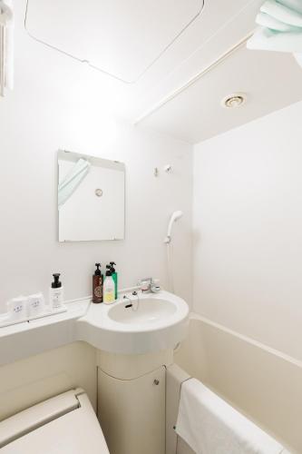 a white bathroom with a sink and a toilet at Nagoya Sakae Green Hotel in Nagoya