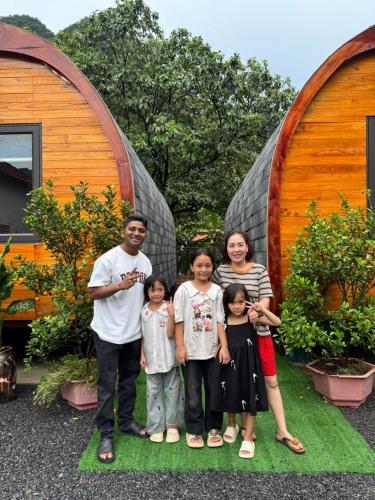 a family posing for a picture in front of a house at Trang an mountain view bungalow in Nguyên Ngoại