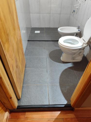 a bathroom with a toilet and a door open at Saltos del Tabay LOGDE in Puerto Leoni