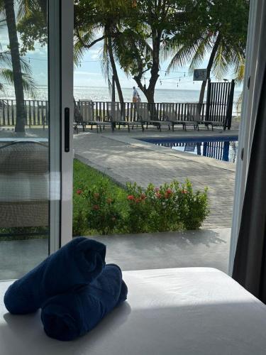 a blue pillow sitting on a bed in front of a window at BigWave Costa Rica in Playa Hermosa