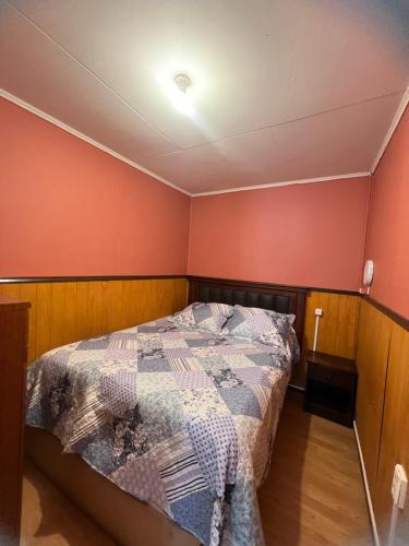 a bedroom with a bed in a room with red walls at Casas Punta Arenas in Punta Arenas