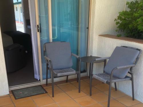 two chairs and a table on a porch at McNevins Maryborough Motel in Maryborough