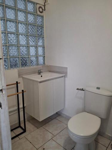 a bathroom with a white toilet and a sink at Hébergement en rez-de jardin clos - Proche de l'aéroport 4km - Parking gratuit - Commerce et restauration à proximité - Wifi in Le Lamentin