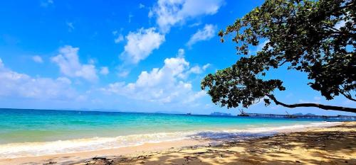 a beach with a tree and the ocean at la la lay beach house in Tab Kaek Beach