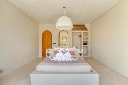 a bedroom with a bed with two flip flops on it at Parisian New 2BR Luxury Villa 8mins walk to Beach in Bingin Beach