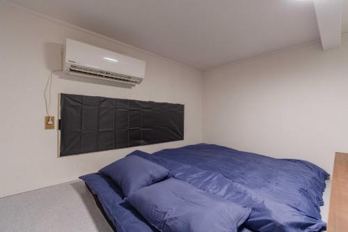 a bedroom with a blue bed and a air conditioner at Chihaya Relaxation Haven in Fukuoka