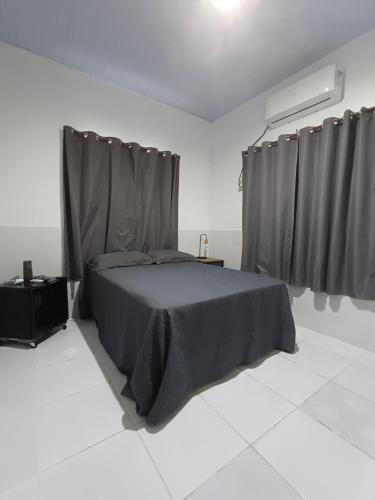 a bedroom with a bed in a white room at Residêncial Fonseca in Juruti