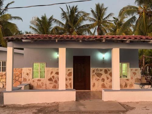 a small house with a porch and palm trees at Casa Tortuga in Chelem