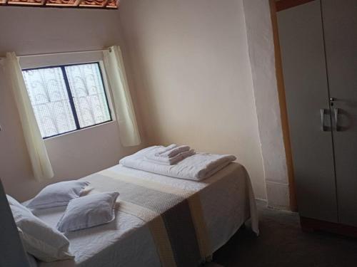 a room with a bed with two pillows on it at Casa Menezes - Ilha do Ferro - Alagoas in Pão de Açúcar
