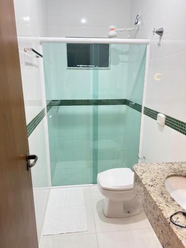 een badkamer met een douche, toilet en wastafel bij Apartamento aconchegante próximo ao mar em Itapoá in Itapoa