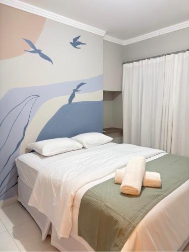 een slaapkamer met een bed met twee handdoeken erop bij Apartamento aconchegante próximo ao mar em Itapoá in Itapoa