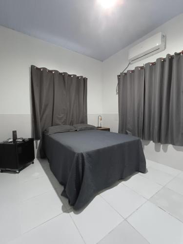 a bedroom with a bed in a white room at Residêncial Fonseca in Juruti