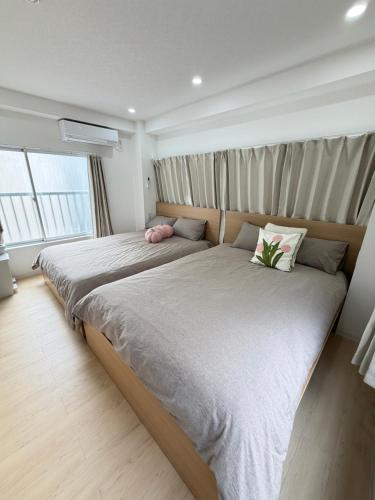 a bedroom with a large bed with two pillows at PUZZLE hotel 301 in Tokyo