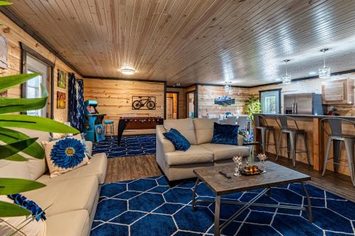 a living room with a couch and a table at Wooded Circle - Barrel sauna, hot tub, fire pit in Hico