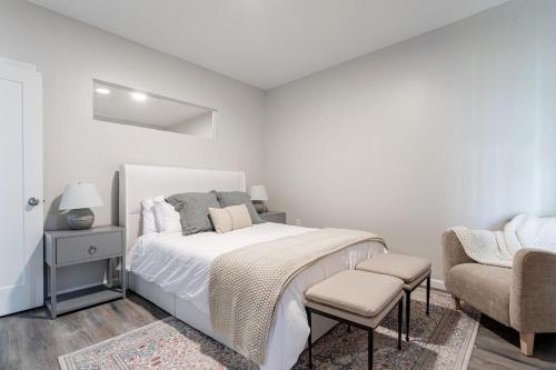 ニューヘイブンにあるDowntown 2BR Gem Yale Wooster Sq WiFiのベッドと椅子のある白い寝室