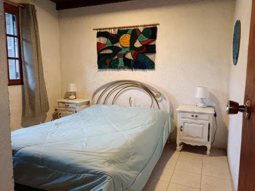 - une chambre avec un lit, 2 tables de nuit et une fenêtre dans l'établissement La casa del agua, à La Pedrera