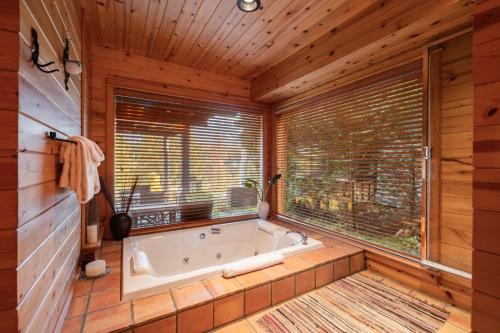 a bath tub in a room with a window at Heron Chalet by Outpost Whistler in Whistler