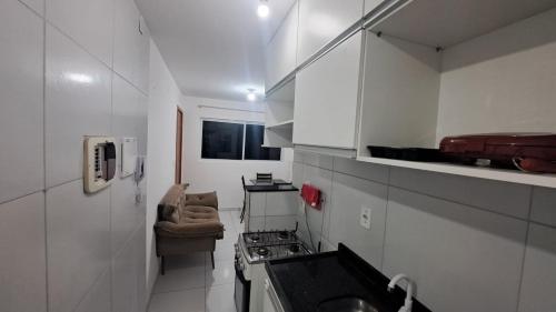 eine kleine weiße Küche mit Herd und Spüle in der Unterkunft Apartamento Mobiliado! in João Pessoa