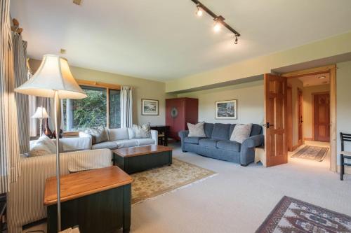 a living room with two couches and a table at Heron Chalet by Outpost Whistler in Whistler