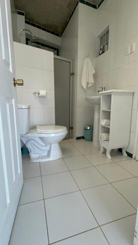 a white bathroom with a toilet and a sink at My little Santorini in Guanaqueros